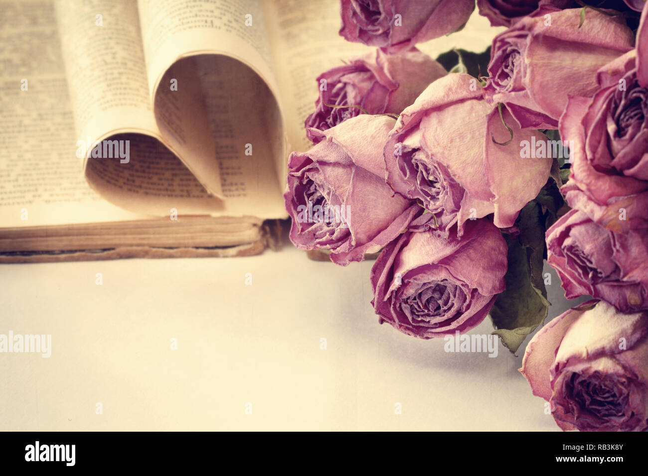 bouquet of dry roses, old book in vintage style Stock Photo Alamy