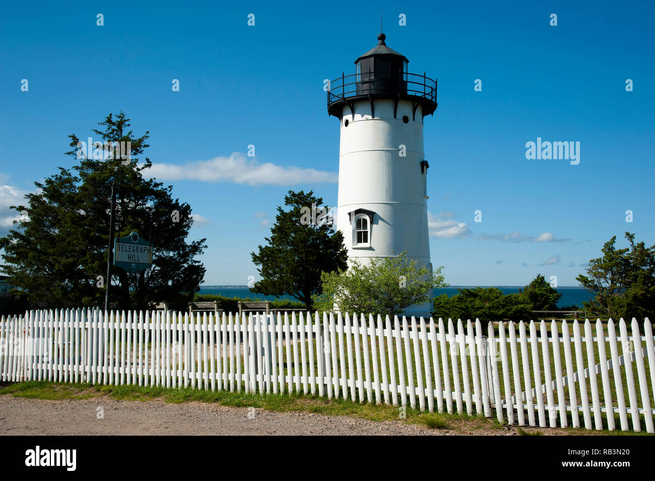 An old white picket fence surrounds East Chop lighthouse tower, on Telegraph Hill, on Martha’s Vineyard Island. It is a popular attraction for the man Stock Photo