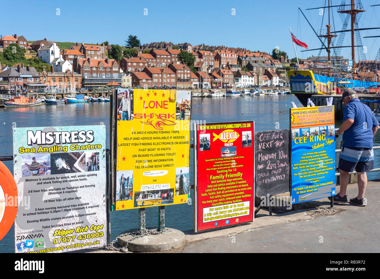 Advertising boards for fishing trips on harbourfront, Whitby, North Yorkshire, England, United Kingdom Stock Photo