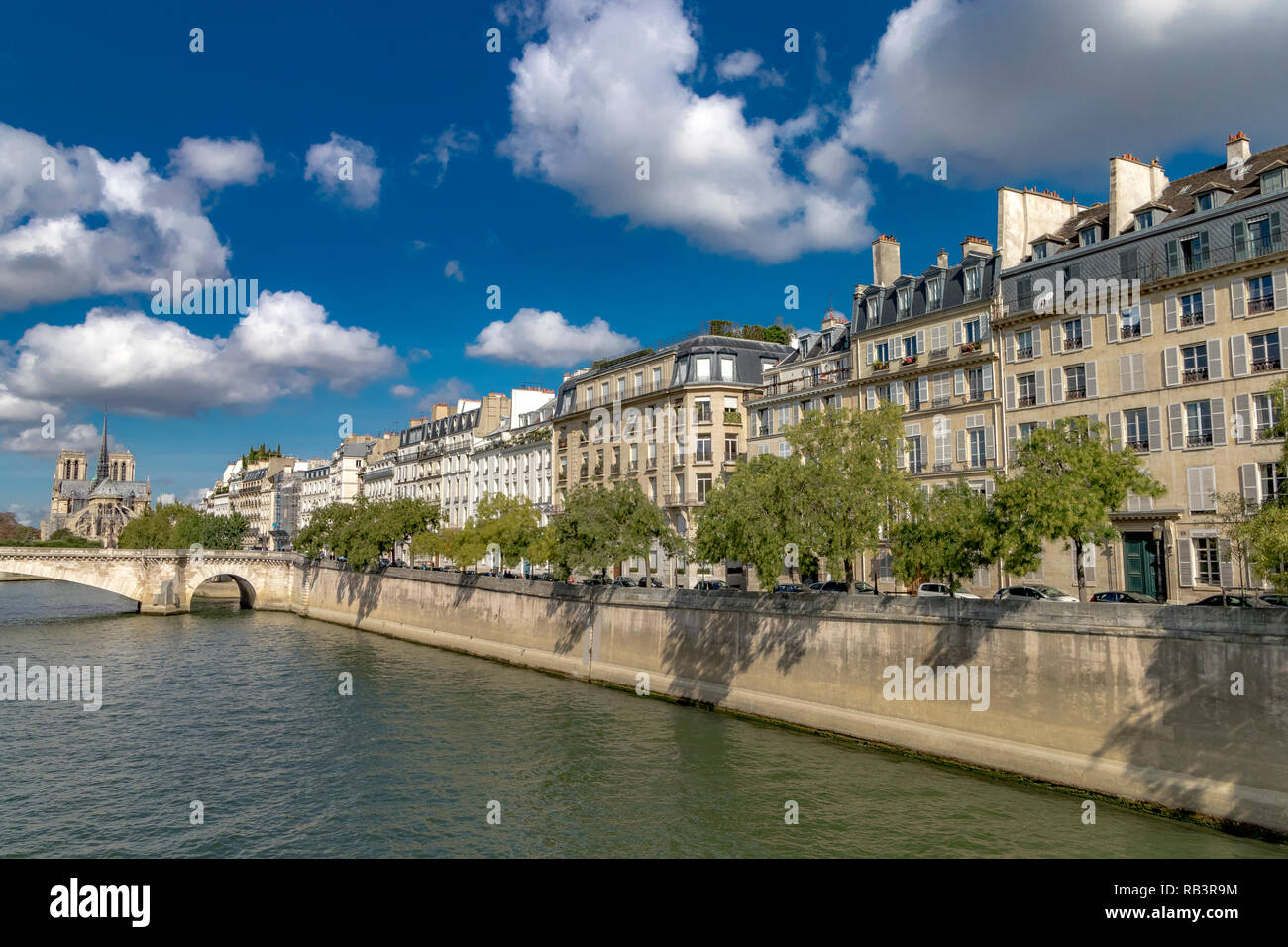 Apartment buildings with white wooden shutters overlooking The River Seine on  Île Saint-Louis ,with Notre-Dame Cathedral in the distance in Paris Stock Photo