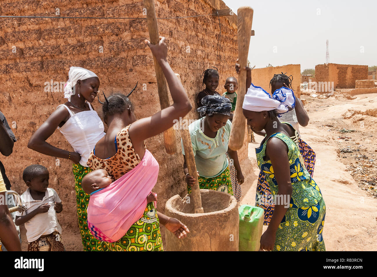 African women crushing cereals with traditional wooden mortar and pestles, Ouagadougou, Burkina Faso. Stock Photo