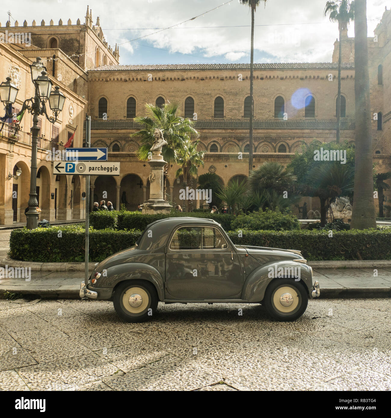 Cute vintage car outside the Cathedral of Monreale, a town in the Metropolitan City of Palermo, Sicily, Italy Stock Photo