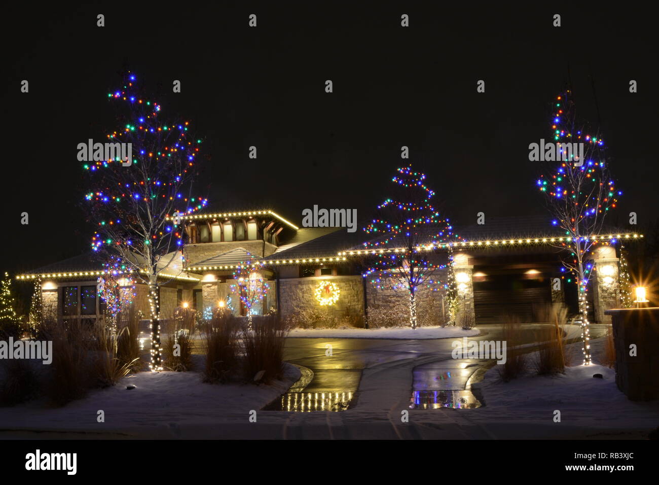 Residential Home Christmas Lights in white with colored trees Stock