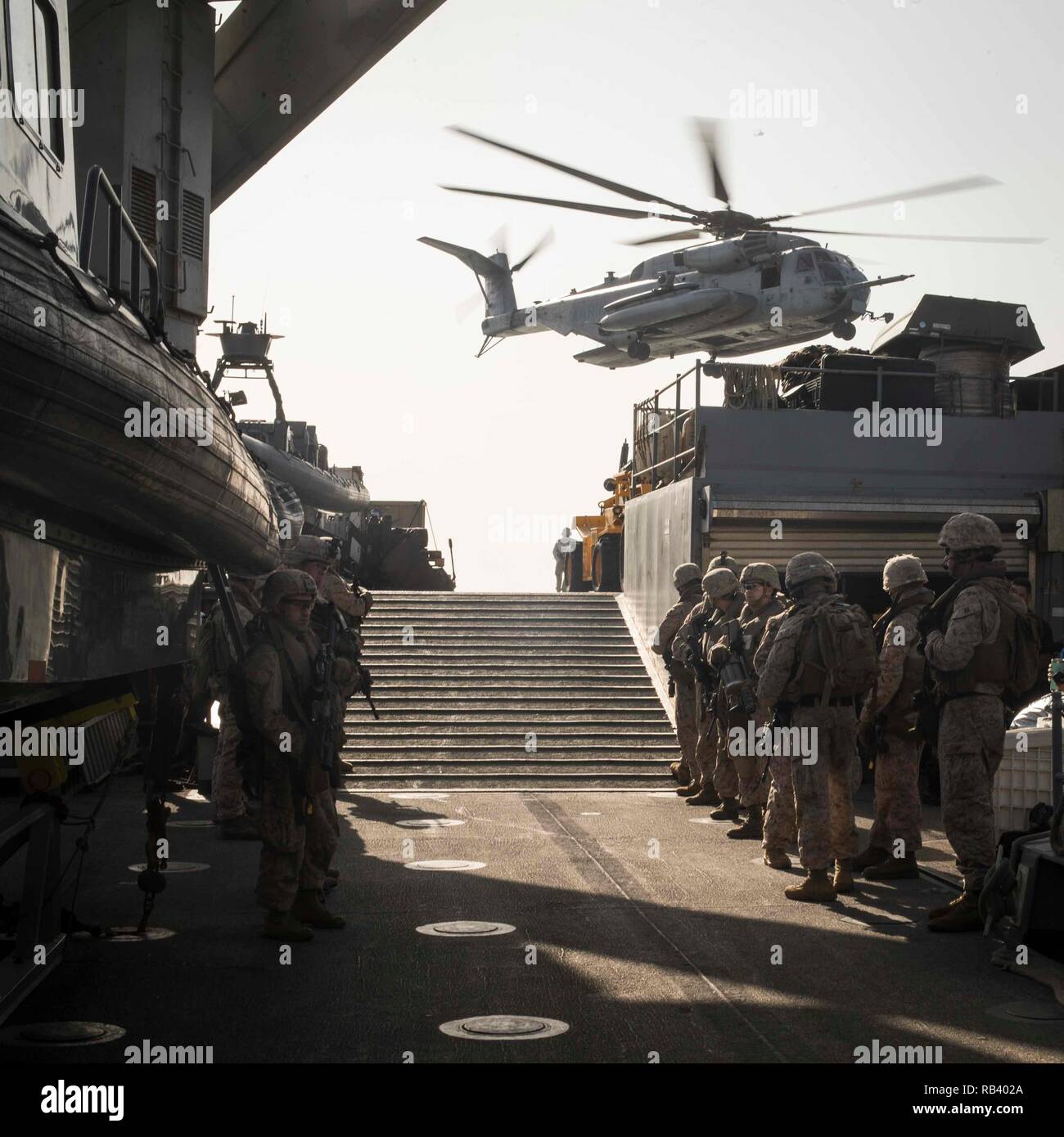 ARABIAN SEA - U.S. Marines with Lima Company, Battalion Landing Team 3/1, 13th Marine Expeditionary Unit (MEU), watch a CH-53E Super Stallion with Marine Medium Tiltrotor Squadron 166 Reinforced, 13th MEU, depart from the Whidbey Island-class dock landing ship USS Rushmore (LSD 47), Jan. 5, 2019. The Essex Amphibious Ready Group and the 13th MEU are deployed to the U.S. 5th fleet area of operations in support of naval operations to ensure maritime stability and security in the Central Region, connecting the Mediterranean and the Pacific through the western Indian Ocean and three strategic chok Stock Photo