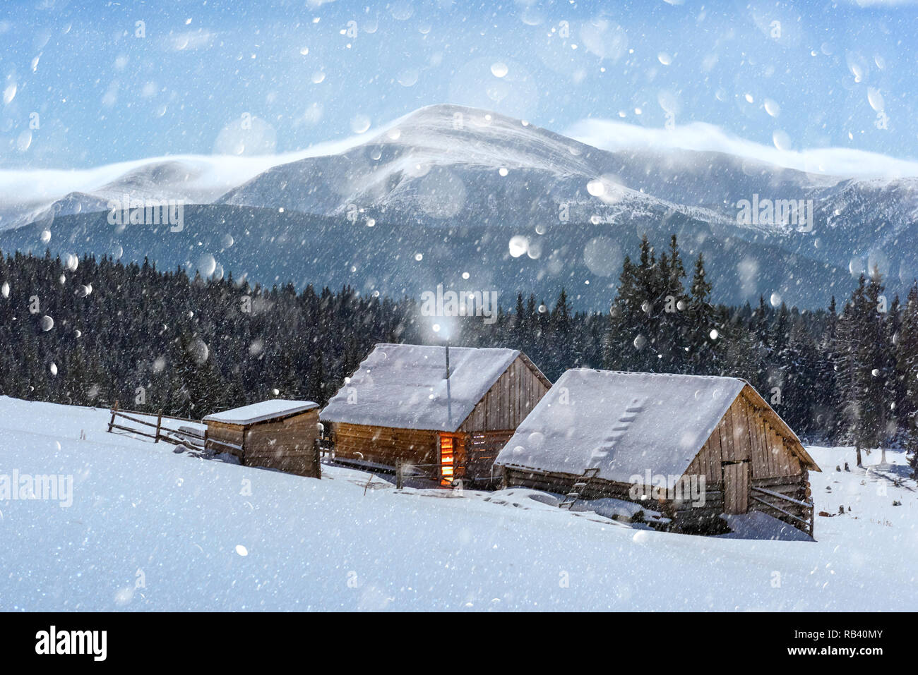 Fantastic night landscape glowing by moon light. Dramatic wintry scene with snowy house. Christmas holiday postcard collage. DOF bokeh light postprocessing effect Stock Photo