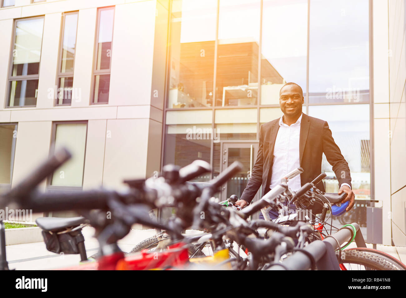 African businessman turns off his bike in front of the office Stock Photo