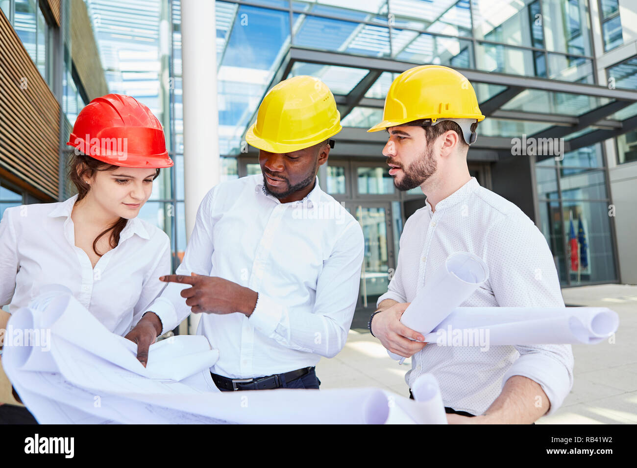 Three business people as architects make as a team the construction project planning Stock Photo