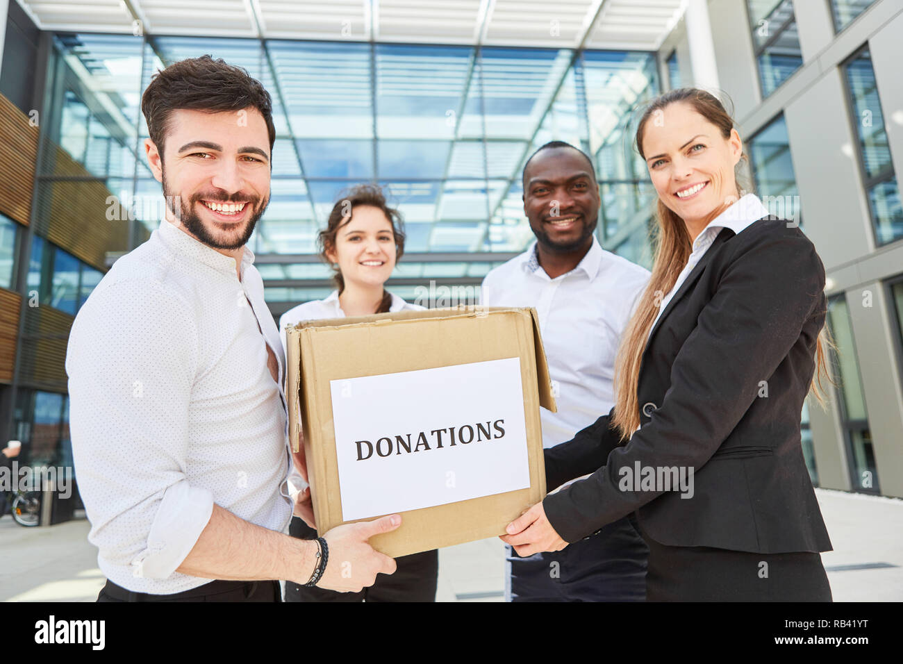Business team with box with a donation as a charitable corporate donation Stock Photo