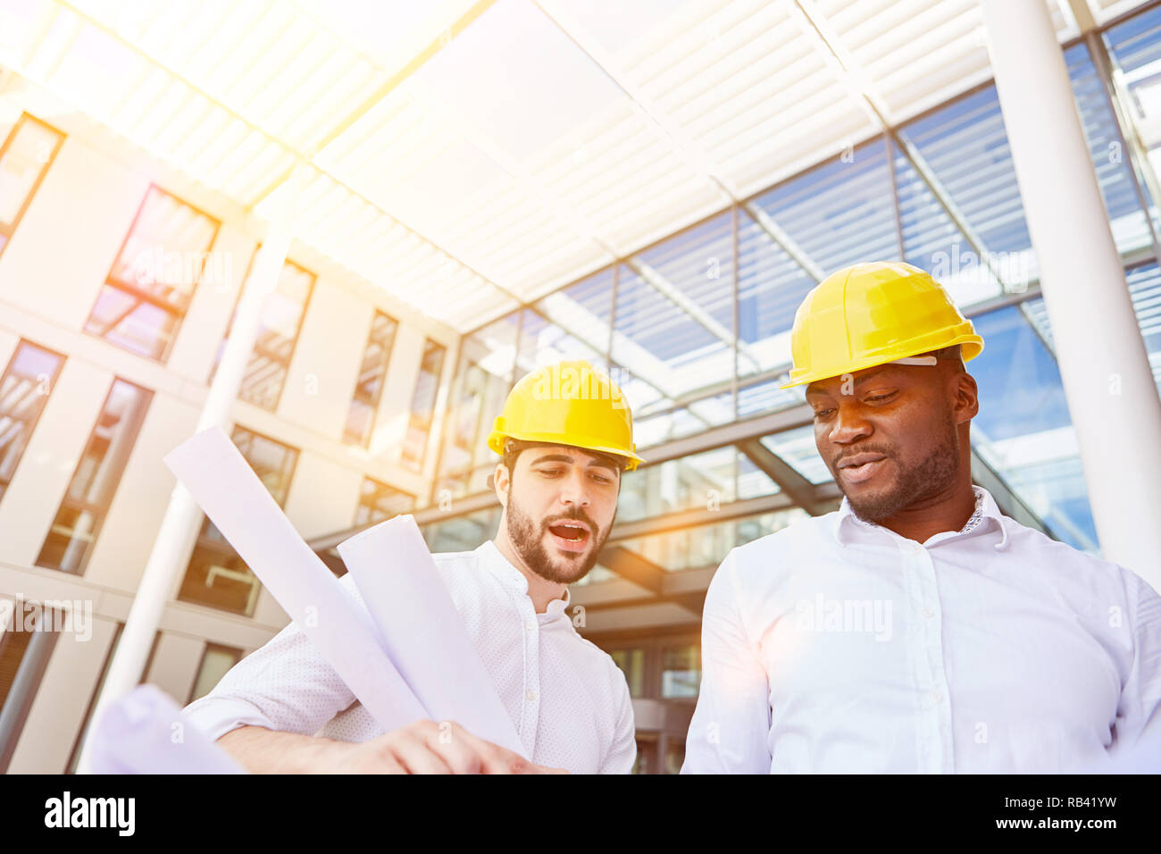 Architect and construction manager at planning meeting in front of a business office building Stock Photo