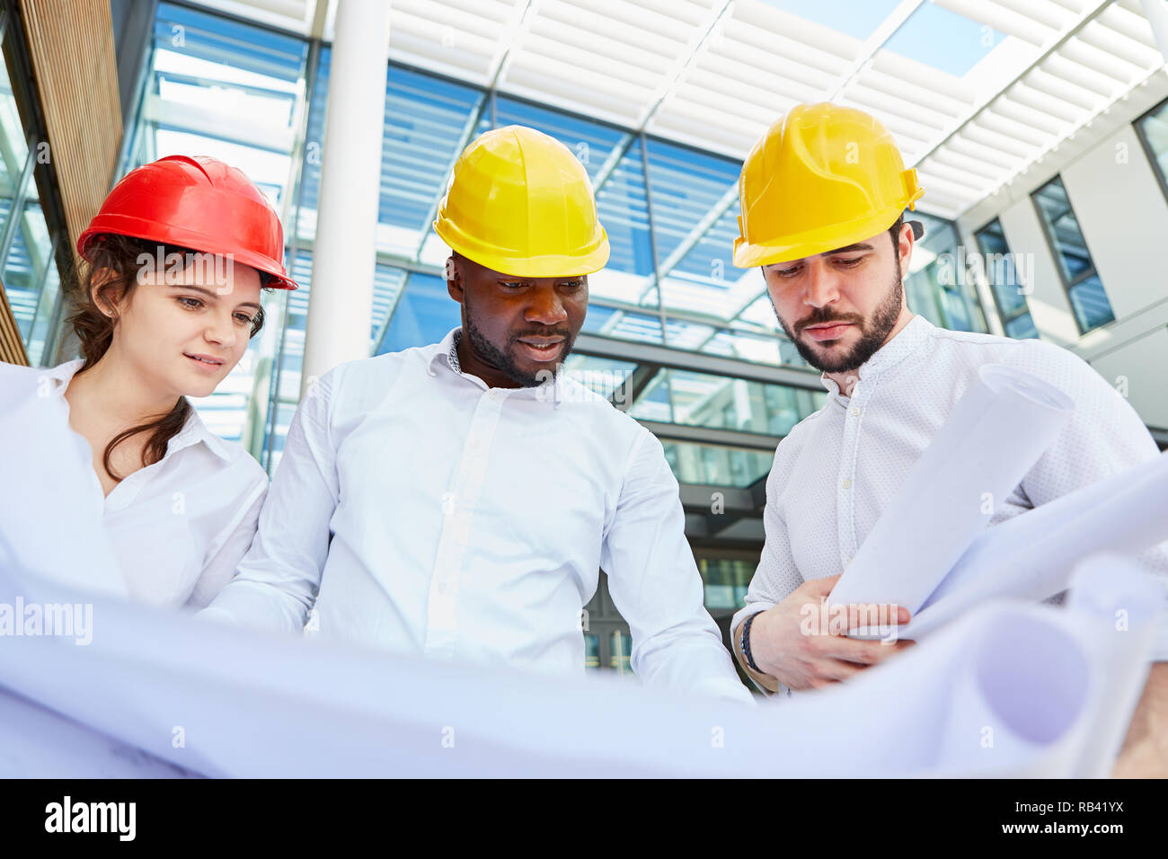 Three engineers and architects as a team in a construction planning meeting Stock Photo