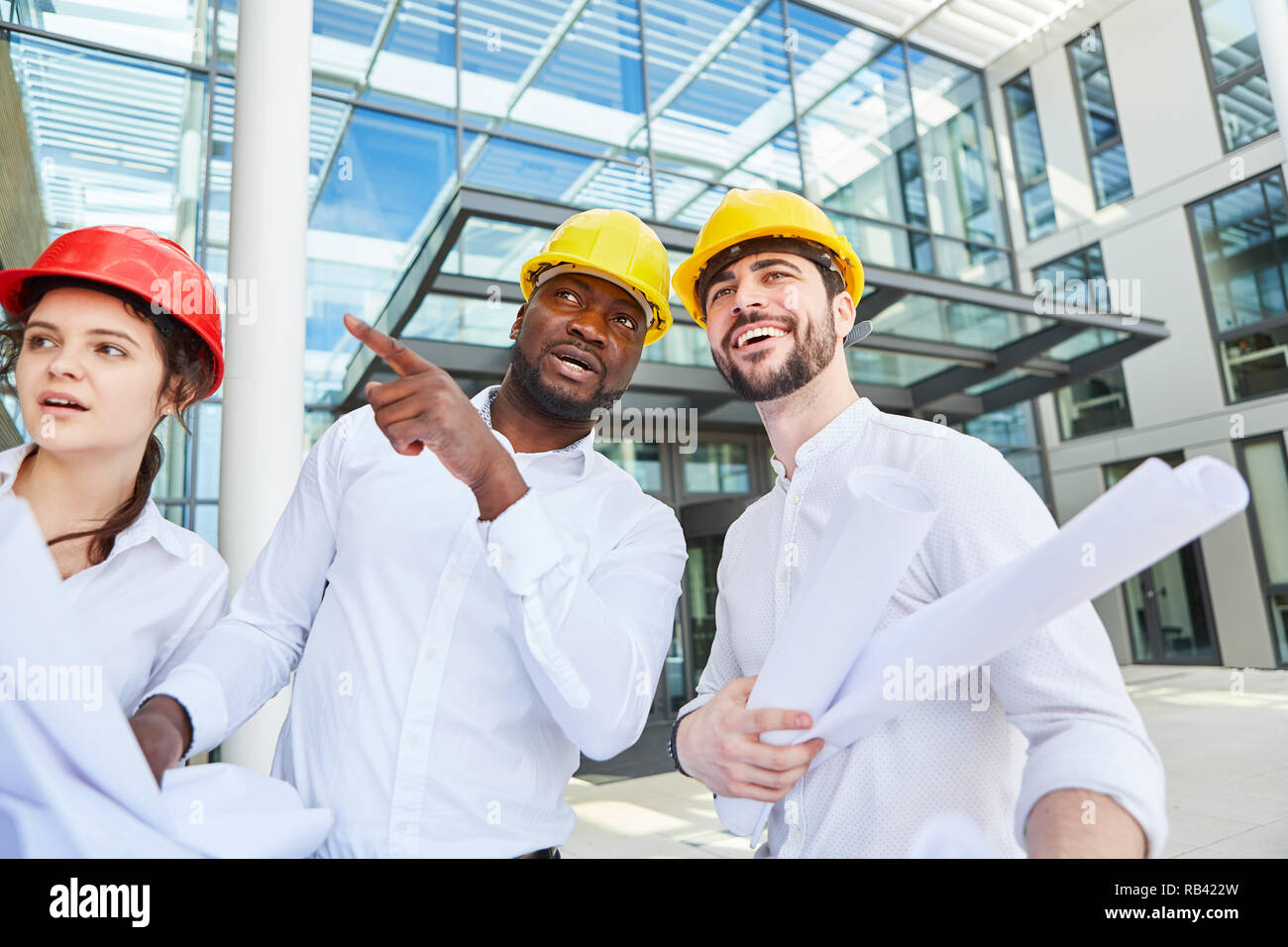 Three business people as architects in a construction planning meeting Stock Photo