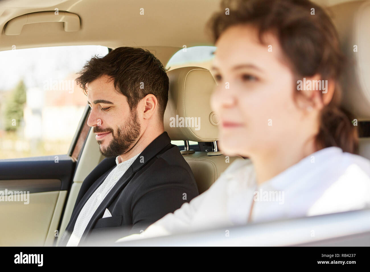 Young couple in the car on the road on business trip or drive to the office Stock Photo