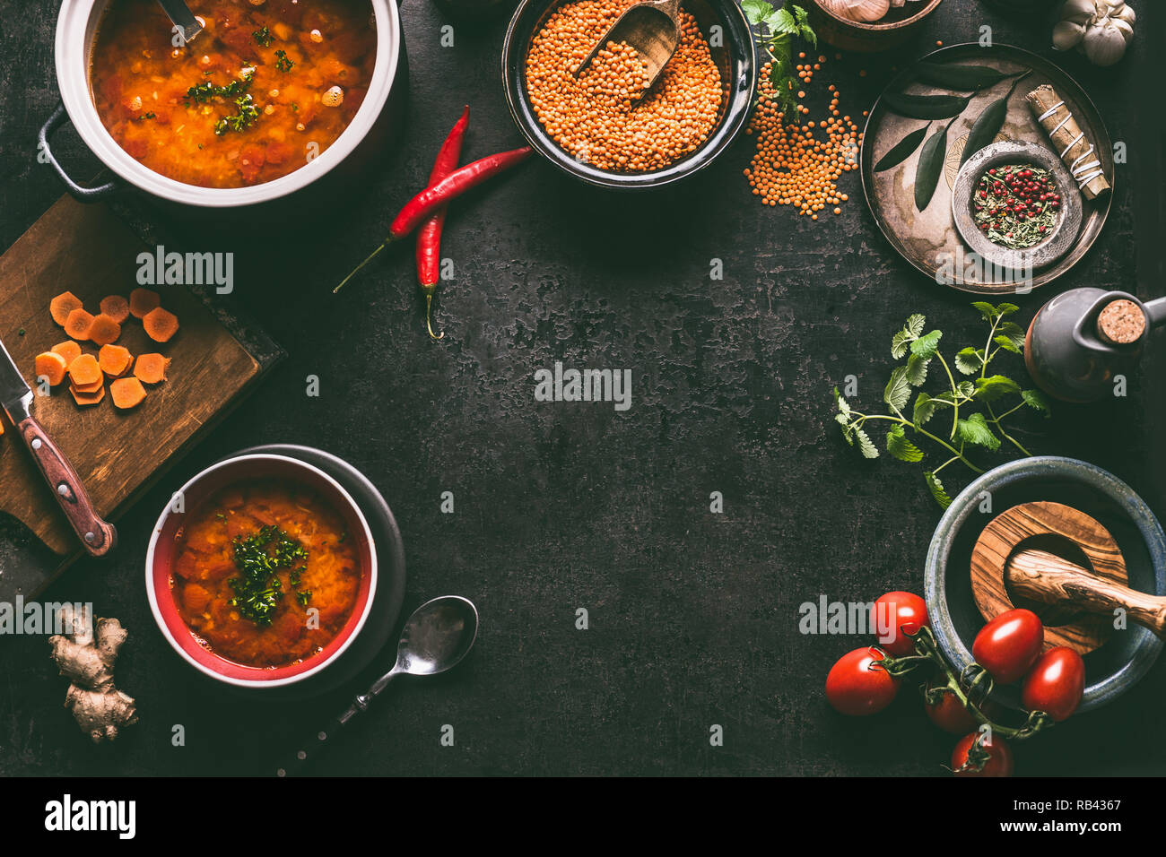 Lentil dishes food background. Lentil soup with cooking ingredients on dark rustic kitchen table background, top view. Healthy vegan food concept. Bla Stock Photo