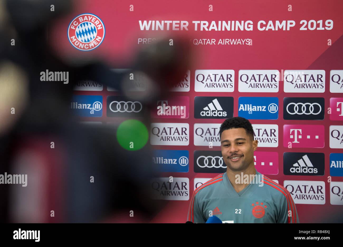 Doha, Qatar. 07th Jan, 2019. Soccer: Bundesliga. Serge Gnabry of FC Bayern  Munich, the German Bundesliga soccer team, is standing in front of a wall  of sponsors during a press conference. FC
