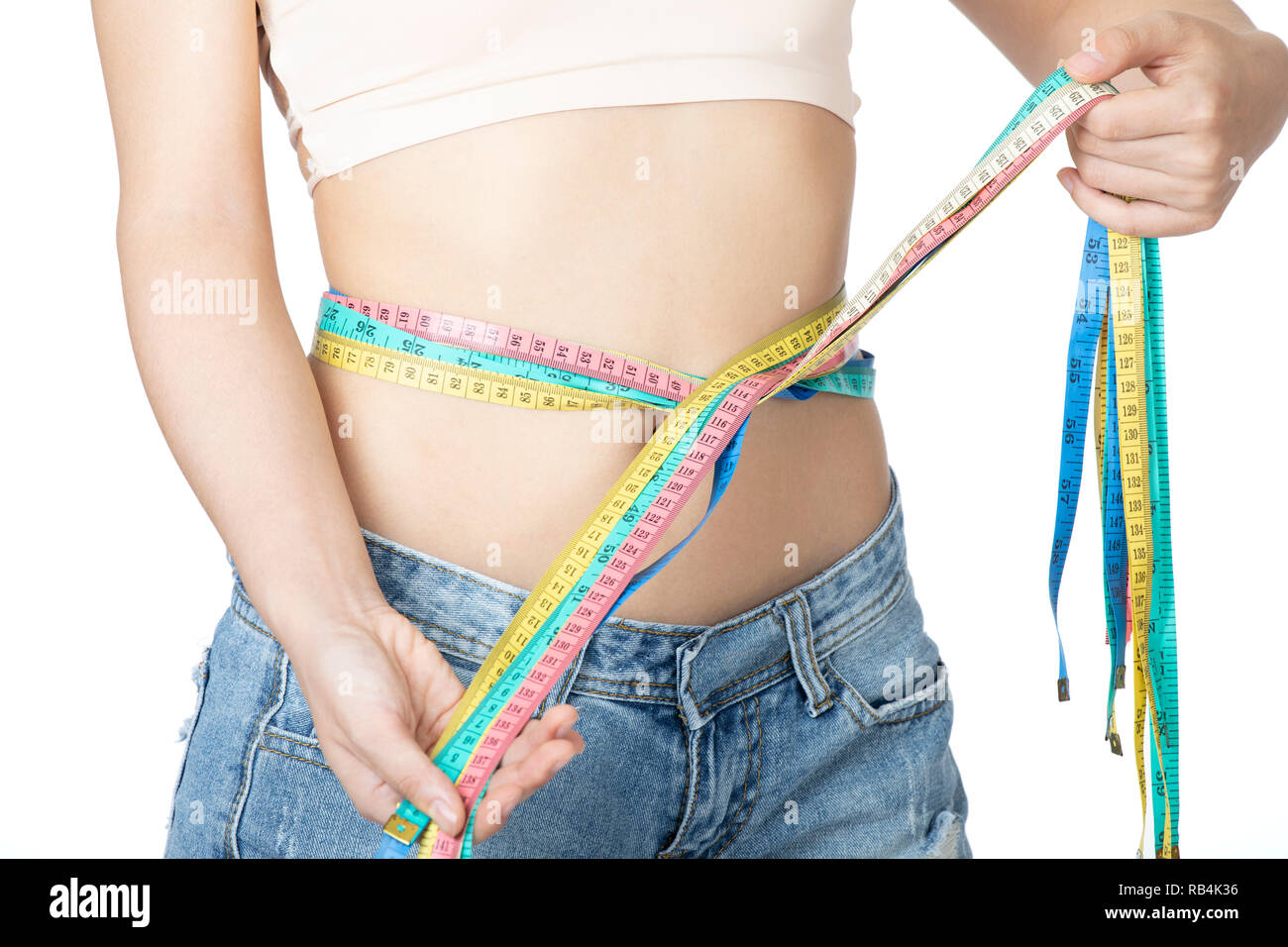 Closeup of a woman's waistline with a tape measure around her flat stomach  Royalty-Free Stock Image - Storyblocks