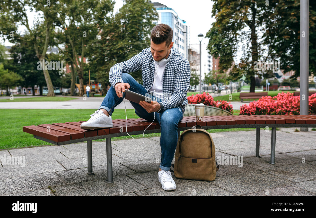 Young man using tablet outdoors Stock Photo