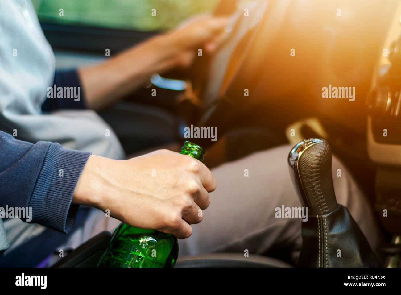 Drinking and driving ,man drinking alcohol and using mobile phone while driving car ,concept drive safely while using a cell phone or drunk alcohol Stock Photo
