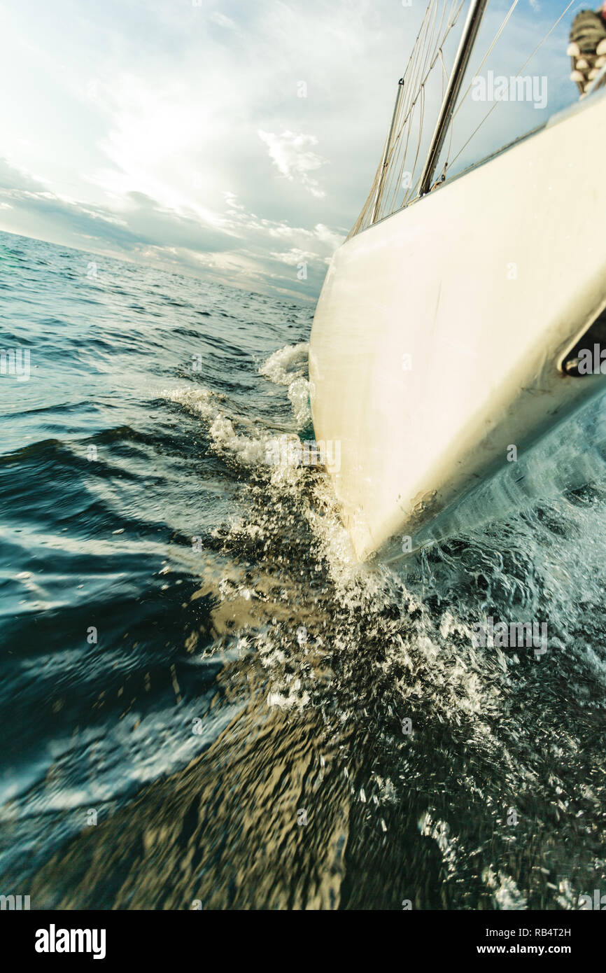 Yachting on sail boat bow stern shot splashing sea water. Sporty