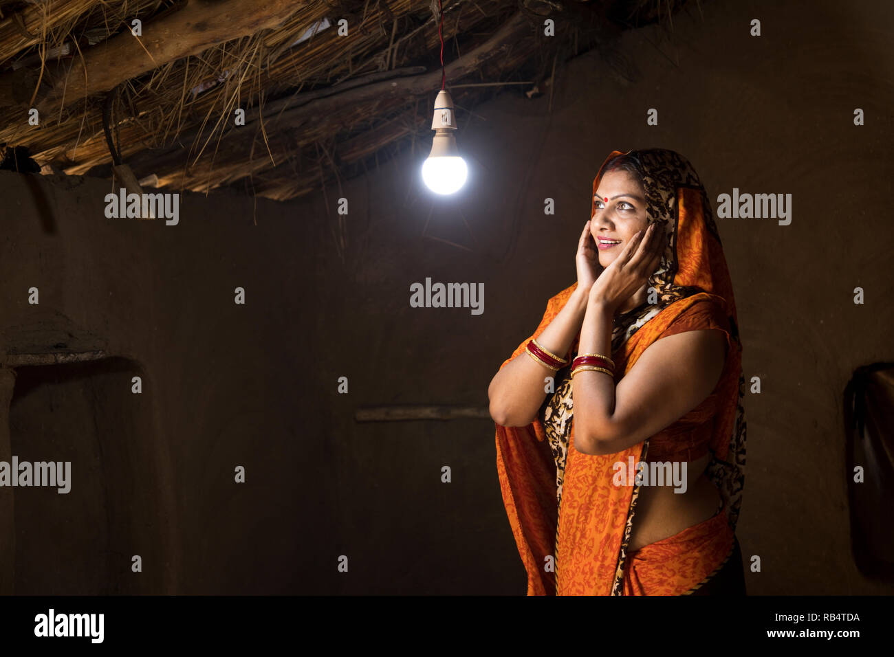 Rural Indian Woman Delighted At The Glow Of Light Bulb And Electricity