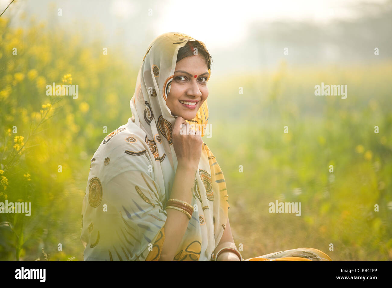 Smiling Indian woman farmer in rapeseed agricultural field Stock Photo ...