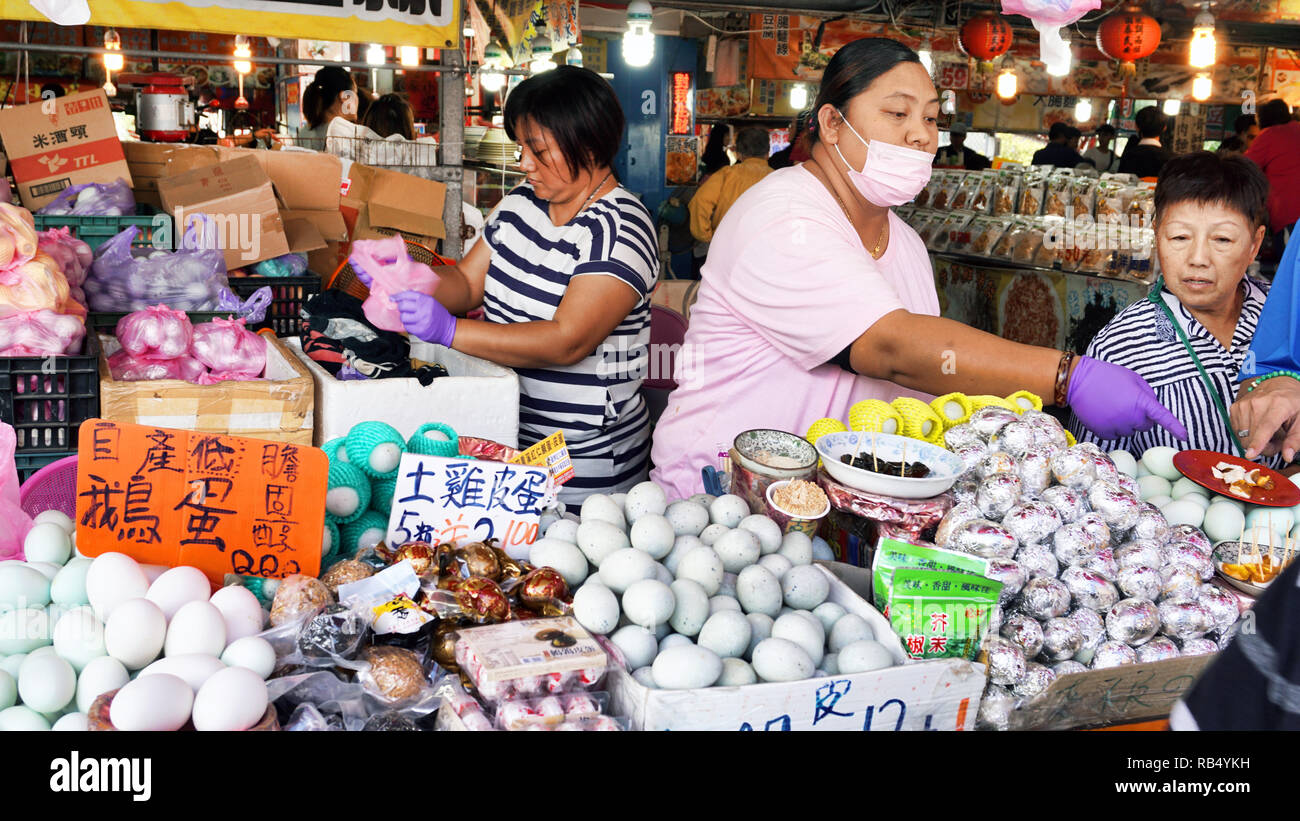 Hengchuni, Taiwan - Dec.8, 2018 - Busy food court in Hengchun,Taiwan with egg lady selling fresh eggs. Stock Photo