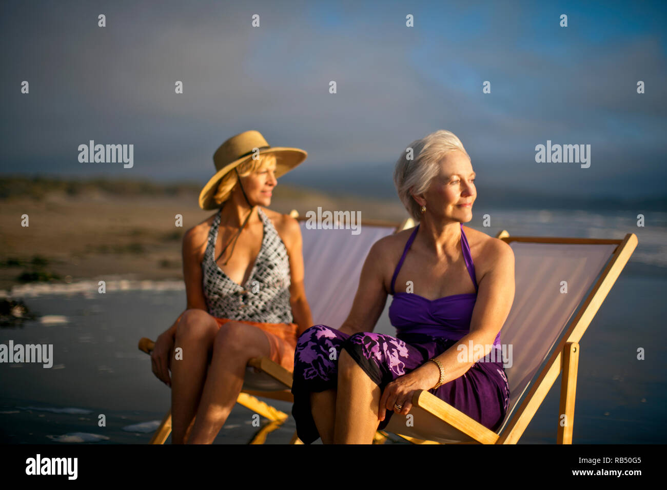 Two happy mature women relaxing in deck chairs on the beach Stock Photo ...