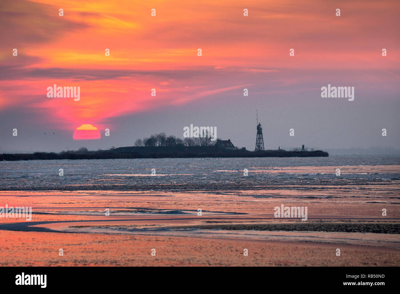 The Netherlands, Amsterdam, Durgerdam. Vuurtoreneiland (Lighthouse Island), a small island in the IJmeer. Winter. Ice. Sunrise. Stock Photo
