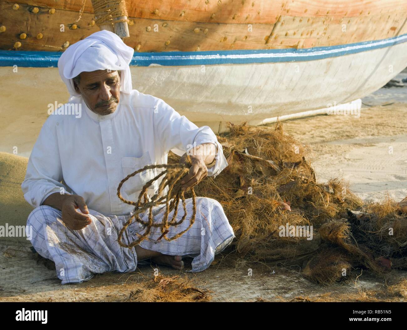 local old man making ropes in a traditional way near the beach of Doha ...
