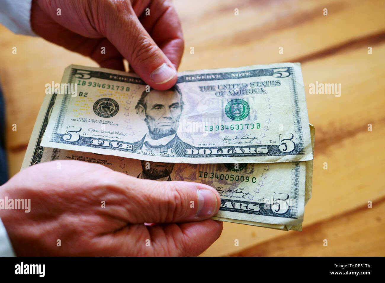 A caucasian man is counting his money on the kitchen table. Stock Photo