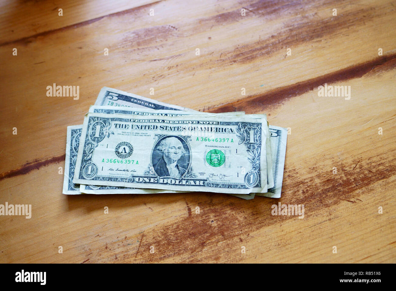 A caucasian man is counting his money on the kitchen table. Stock Photo