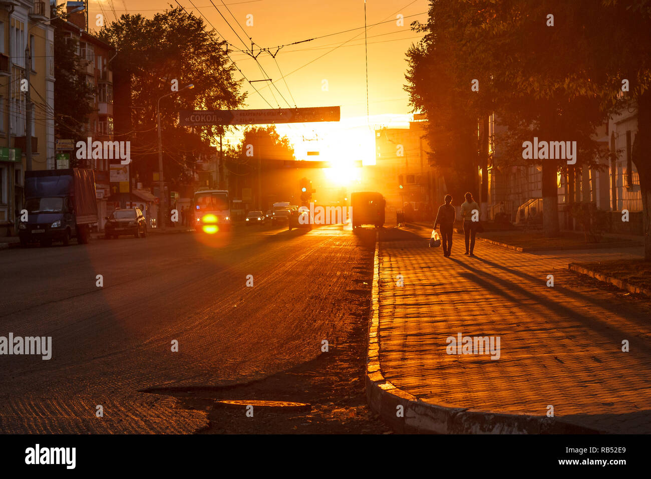 sunset on the city street with pedestrians and cars Stock Photo - Alamy