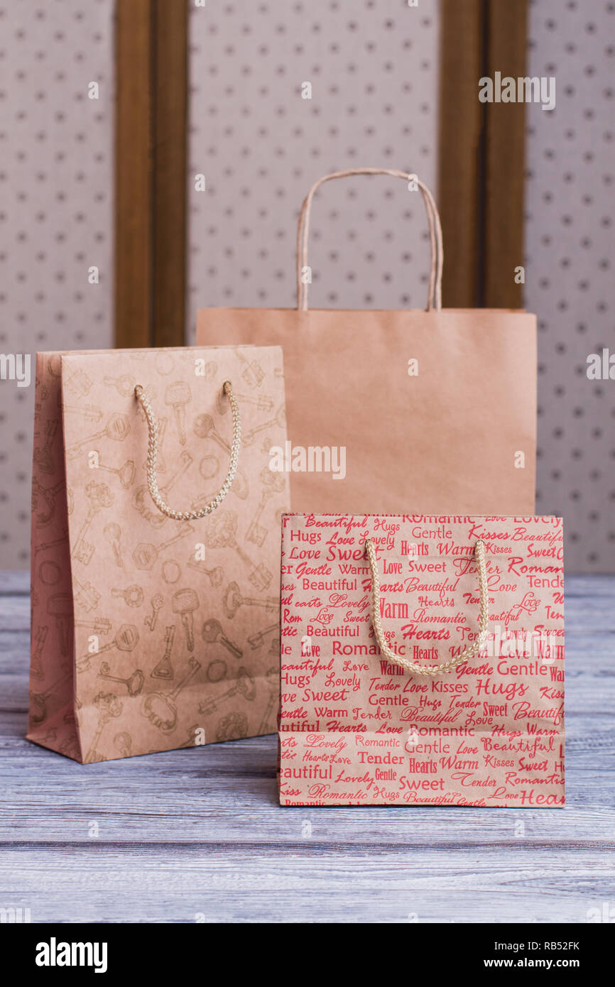 Kraft paper shopping bags. Three brown paper gift bags with printing
