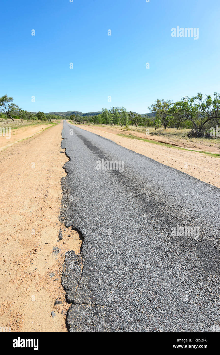 Part of the Savannah Way is a narrow ribbon road with damaged edges, Queensland, QLD, Australia Stock Photo