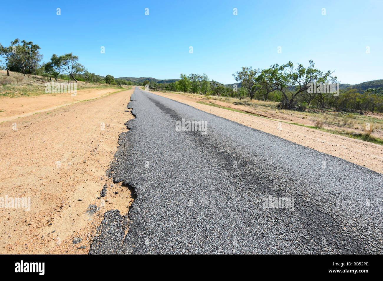 Part of the Savannah Way is a narrow ribbon road with damaged edges, Queensland, QLD, Australia Stock Photo