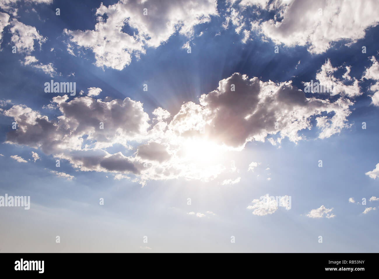 sunlight bursting in clouds and blue sky Stock Photo
