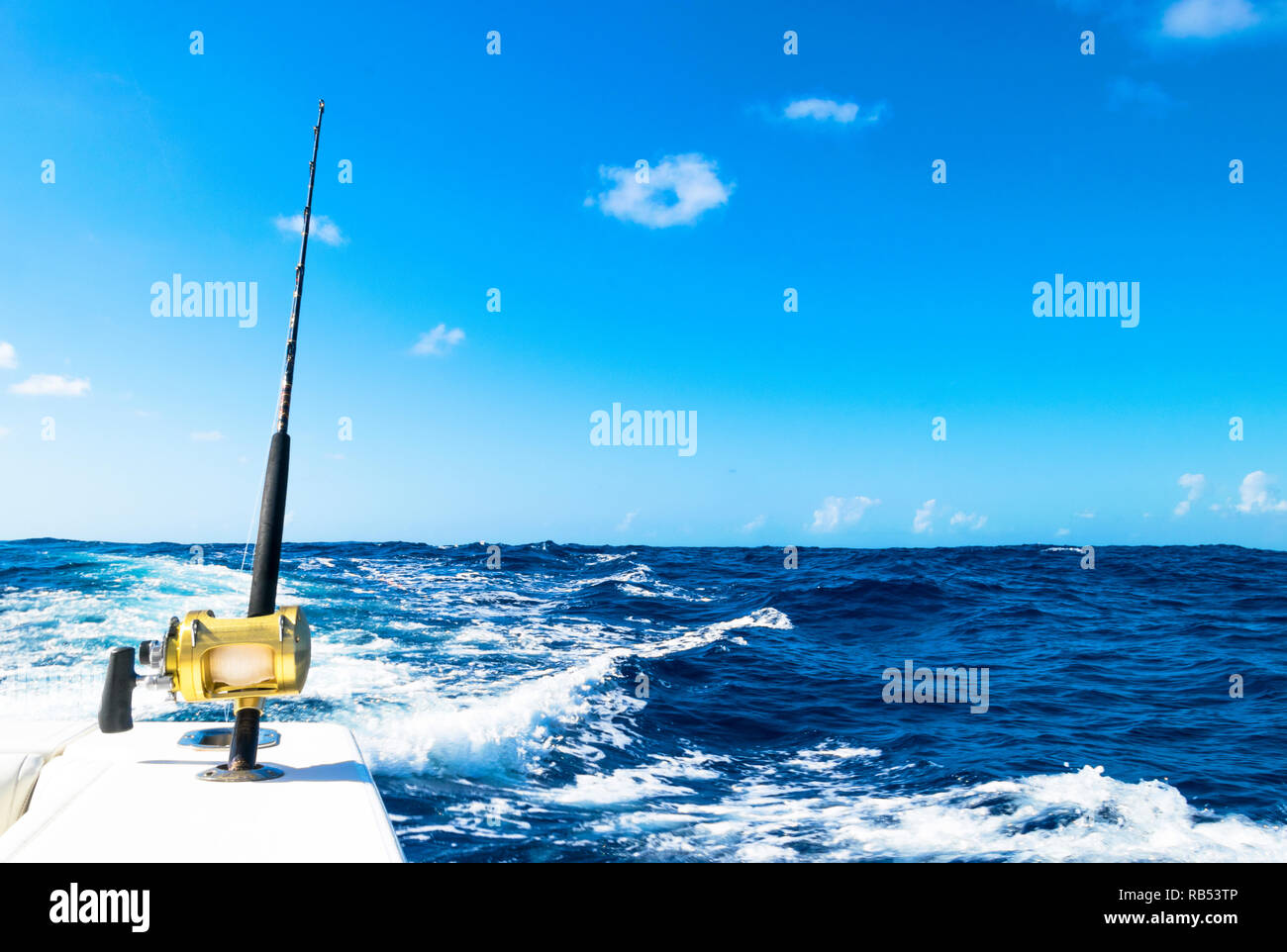 Fishing rod in a saltwater boat during fishery day in blue ocean. Successful fishing concept