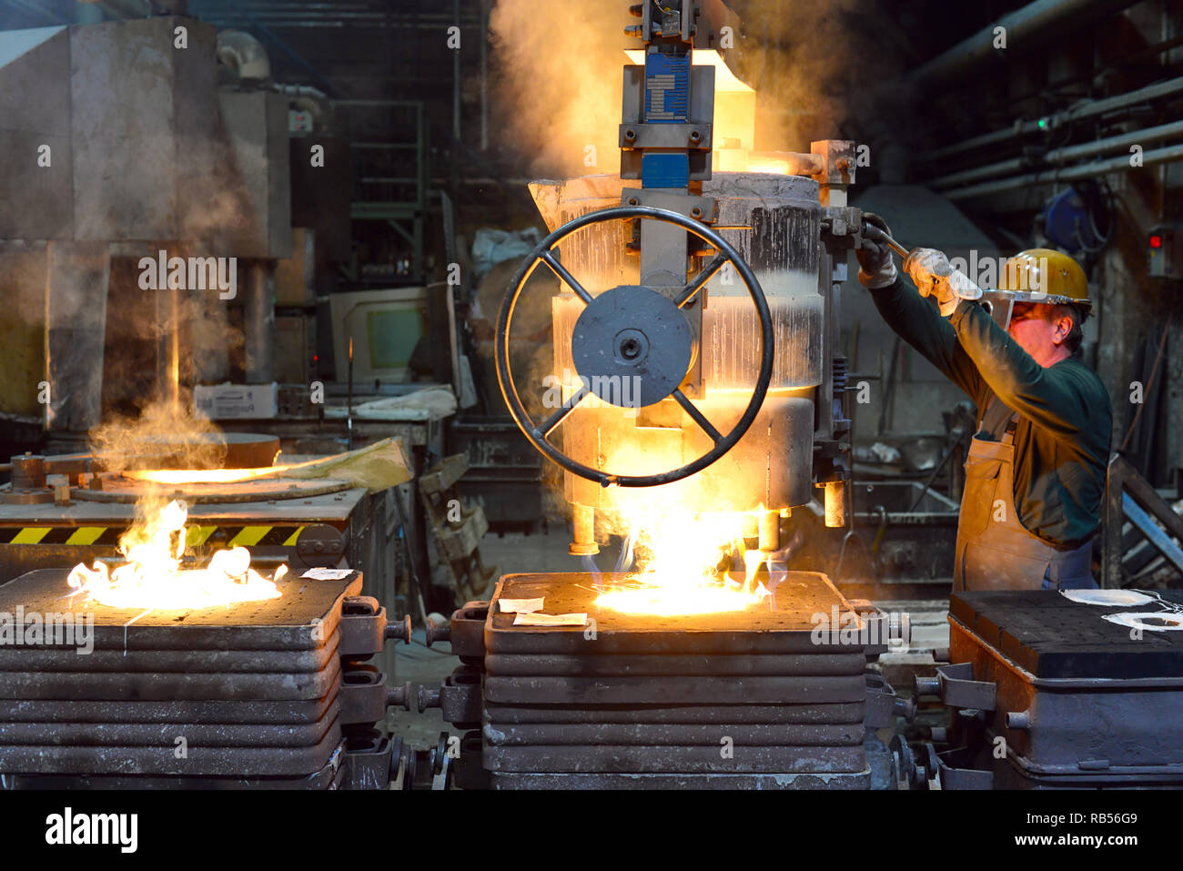 workers in a foundry casting a metal workpiece safety at work and