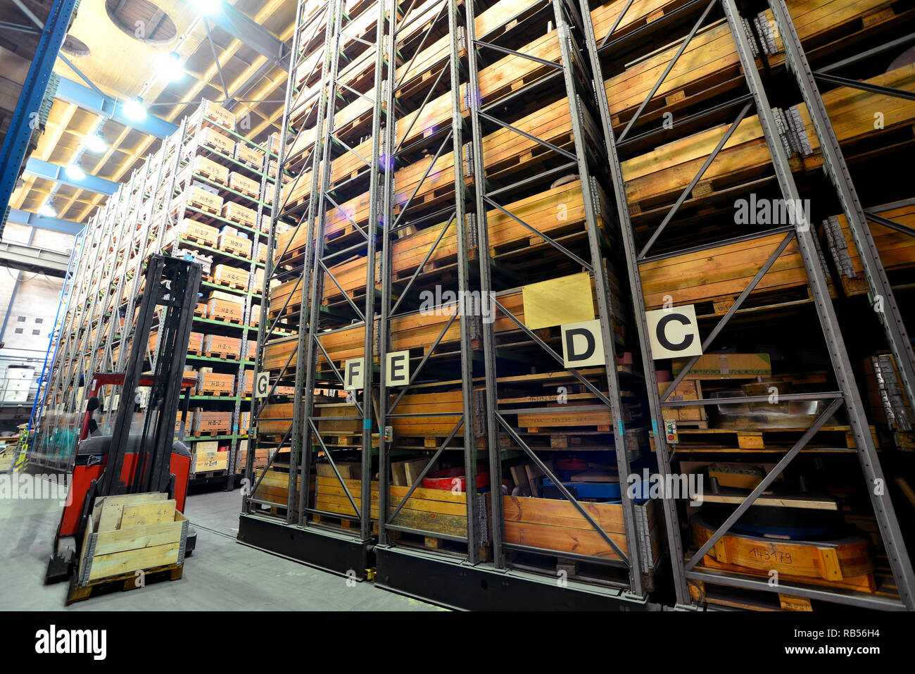 forklift trucks in a high-bay warehouse - storage of goods in an industrial  company Stock Photo - Alamy