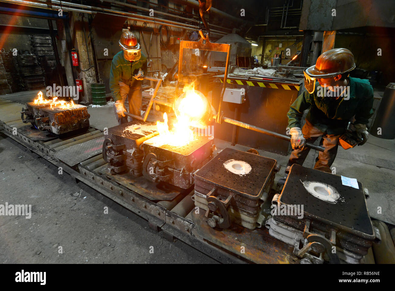 workers in a foundry casting a metal workpiece safety at work and