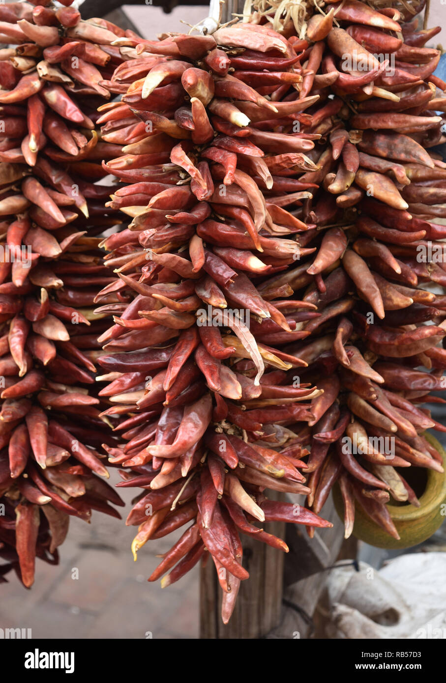 Three clumps of red chili peppers hanging and drying Stock Photo - Alamy