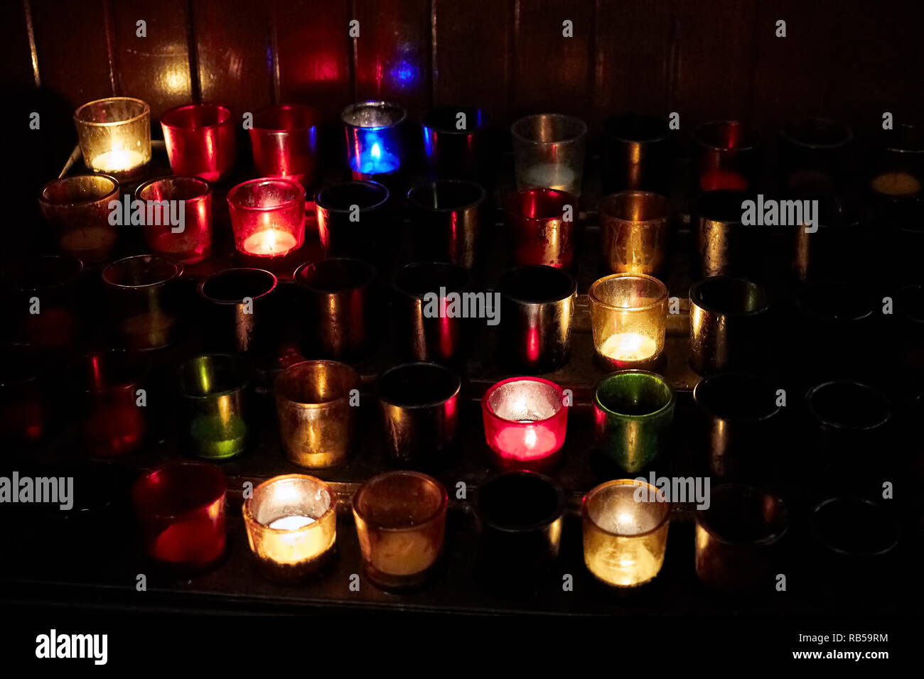Church candles in colorful transparent chandeliers. Symbol of christian