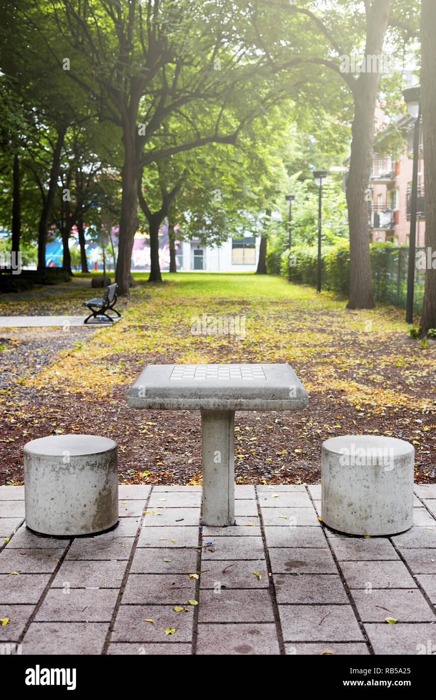 Outdoor concrete chess table and two seats in a public park in Montreal