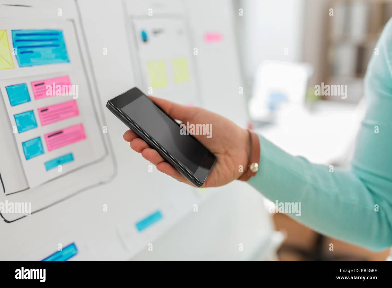ui designer or developer hand holding smartphone Stock Photo