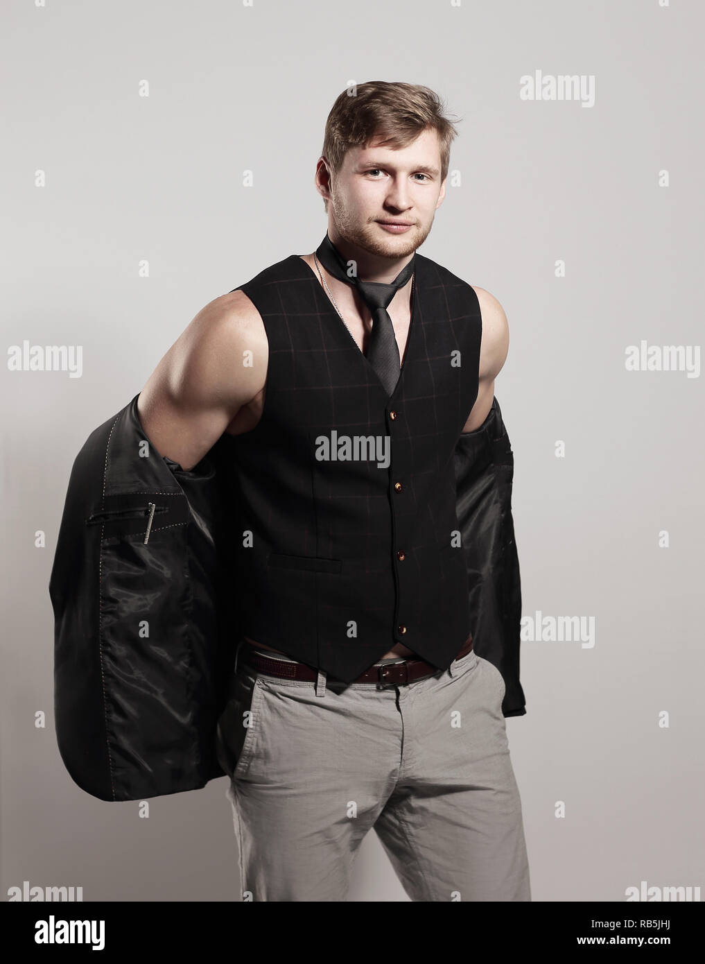 young businessman in a business suit without a shirt holds a jacket over his shoulder Stock Photo