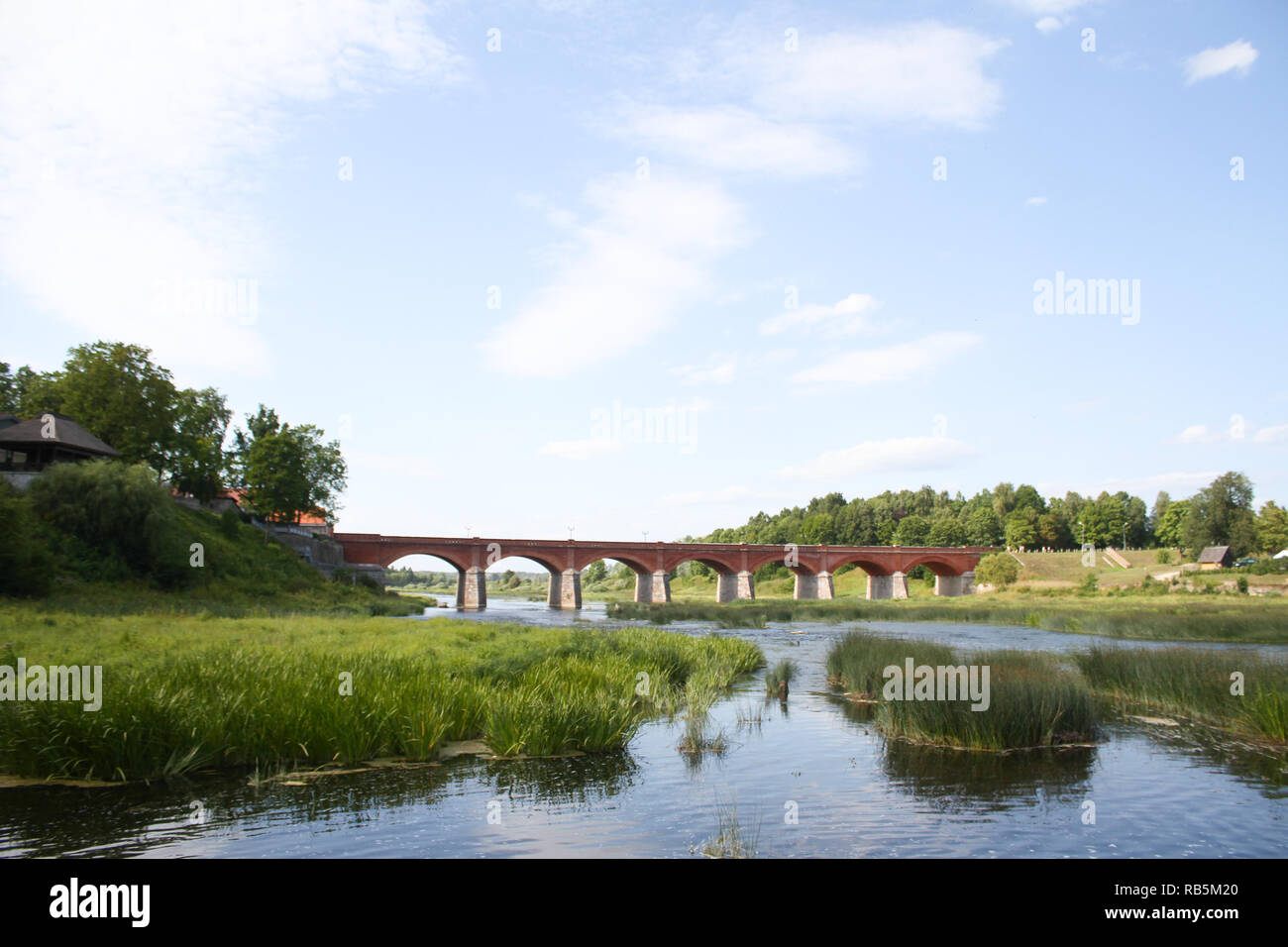Beautiful, countryside,village,view of old, ancient red brick bridge over small river named Venta. Located in Latvia - Europe. Stock Photo