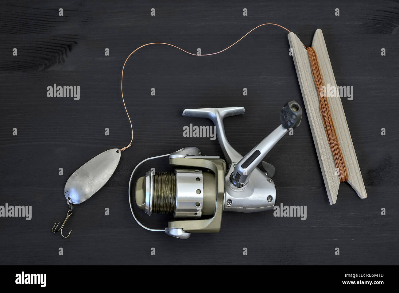 A modern spinning reel with a fishing line and a homemade spoon