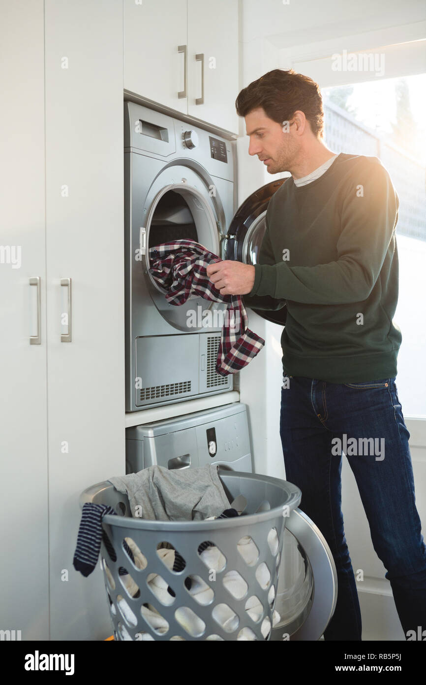 Man putting clothes in washing machine Stock Photo Alamy