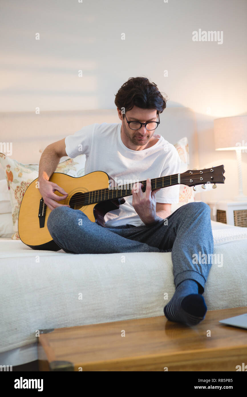 Man playing guitar in bedroom Stock Photo Alamy