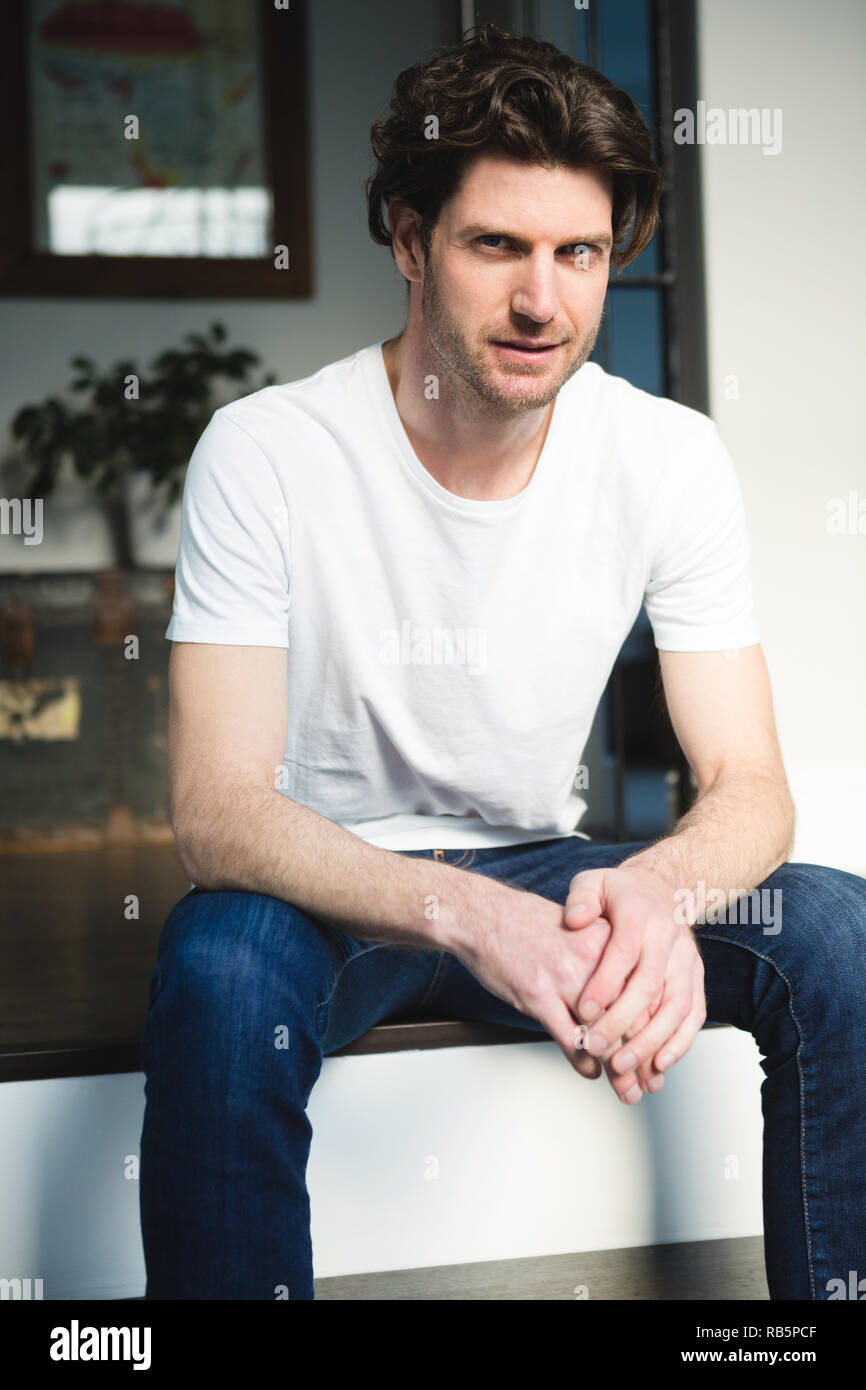 Man sitting on stairs at home Stock Photo - Alamy