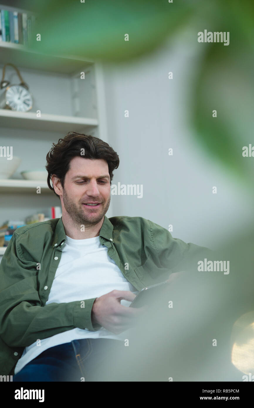 Man using digital tablet in living room Stock Photo